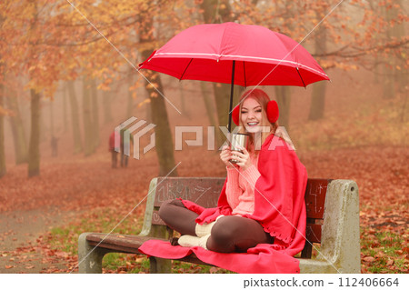 Woman drinking hot coffee relaxing in autumn park 112406664