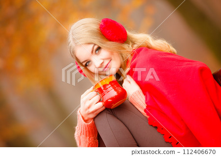 Girl in autumn park enjoying hot drink Girl in autumn park enjoying hot drink 112406670