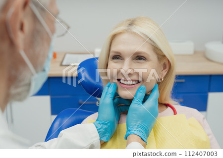 Woman smiling during her dental treatment at dentist. Woman smiling during her dental treatment at dentist. 112407003