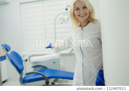 Woman working in dental clinic and doctor in background. Woman working in dental clinic and doctor in background. 112407011