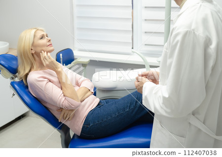 Woman smiling during her dental treatment at dentist. Woman smiling during her dental treatment at dentist. 112407038