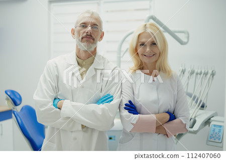 Male and female dental doctors wearing face sitting at his clinic. High quality photo 112407060