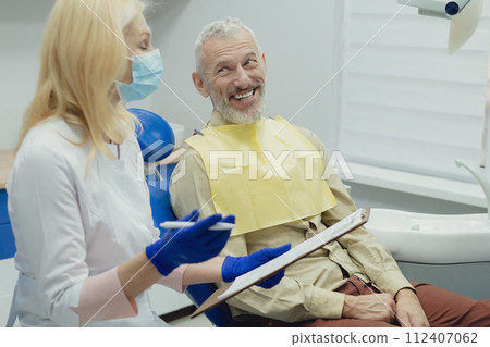 Male smiling during her dental treatment at dentist. 112407062