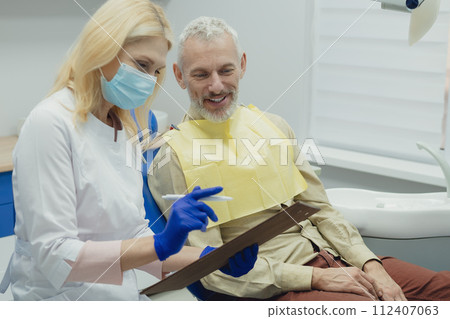 Male smiling during her dental treatment at dentist. 112407063