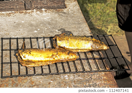 Mackerel fish in a marinade on a wire rack in a smokehouse is ready. The process of cooking hot smoked mackerel Mackerel fish in a marinade on a wire rack in a smokehouse is ready. The process of cooking hot smoked mackerel 112407141