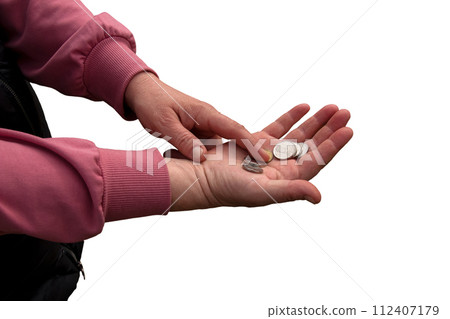 Last money for groceries. Coins in the hand of a middle-aged woman. The concept of the world food crisis associated with the war in Ukraine. Isolated on white background Last money for groceries. Coins in the hand of a middle-aged woman. The concept of the world food crisis associated with the war in Ukraine. Isolated on white background 112407179