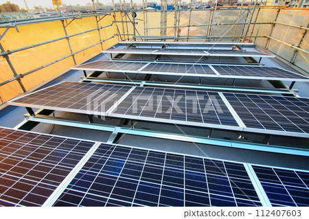 Flat roof under construction... [Solar power generation panels] installed on a pedestal 112407603