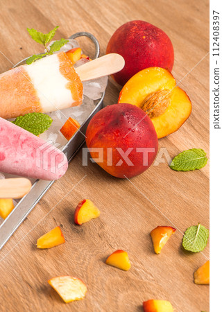 Homemade raspberries and peach popsicles 112408397