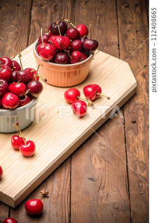 Red ripe cherries in ceramic bowls 112408665