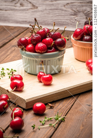 Red ripe cherries in ceramic bowls 112408667