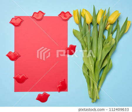 Bouquet of blooming yellow tulips with green leaves on a blue background, top view Bouquet of blooming yellow tulips with green leaves on a blue background, top view 112409633