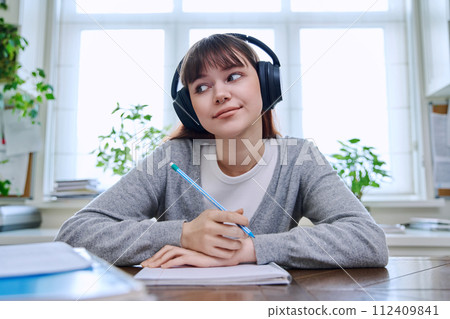 Web camera view of teenage student girl in headphones looking at camera 112409841