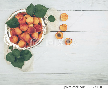 Apricots with leaves. Fresh apricots on the table. Recipe. Healthy food concept. Flat lay. 112411050