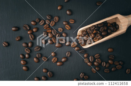 Coffee background.. coffee beans spilling out of scoop. coffee beans closeup on a dark background. 112411658