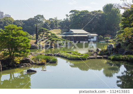 [Japan] Japanese houses visible through the pond and pine trees of Kiyosumi Garden, Tokyo 112413881