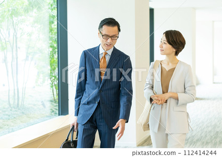 走在辦公室走廊的中年商務人士 走在辦公室走廊的中年商務人士 112414244