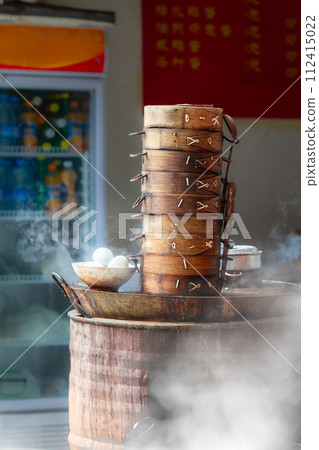 Street food in China. The Boiled eggs and chinese buns in bamboo steamer tray for breakfast on the street shop in China. Street food in China. The Boiled eggs and chinese buns in bamboo steamer tray for breakfast on the street shop in China. 112415022