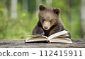 cute brown bear cub reading book in the woods, 16:9 widescreen backdrop / wallpaper 112415911