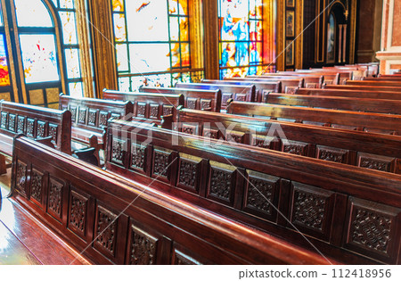Empty wooden church benches of a Christian church. Blurry alter in the background. Selective focus. Concept of church service or empty churches. 112418956