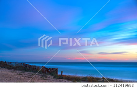 Abstract Beach Sunset with Pink and Blue Clouds, Silky Water and Cottony Sky Abstract Beach Sunset with Pink and Blue Clouds, Silky Water and Cottony Sky 112419698