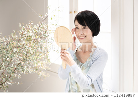 窗邊拿著鏡子的美女 112419997