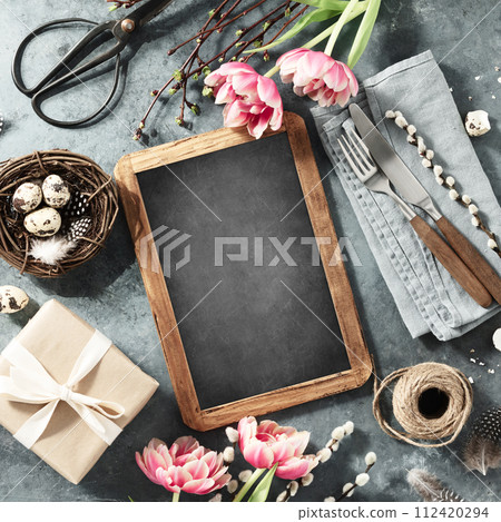 vintage chalk board, spring flowers and cutlery on dark blue background 112420294