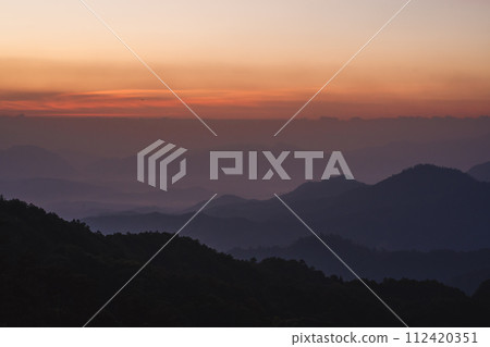 nature traveling with orange sky and layer of mountain with sunrise background nature traveling with orange sky and layer of mountain with sunrise background 112420351