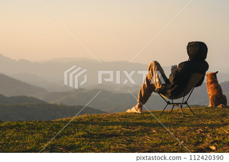 nature traveling with solo man play with dog and see sunrise with layer of mountain 112420390