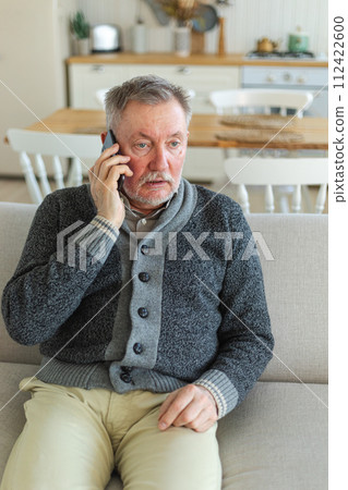 Happy middle aged senior man talking on smartphone with family friends. Older mature grandfather with cell phone talking with grown up children, resting at home. Older generation modern tech usage Happy middle aged senior man talking on smartphone with family friends. Older mature grandfather with cell phone talking with grown up children, resting at home. Older generation modern tech usage 112422600