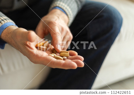 Hands with pills. Senior man hands holding medical pill. Mature old senior grandfather taking medication cure pills vitamin. Age prescription medicine healthcare therapy concept Hands with pills. Senior man hands holding medical pill. Mature old senior grandfather taking medication cure pills vitamin. Age prescription medicine healthcare therapy concept 112422651
