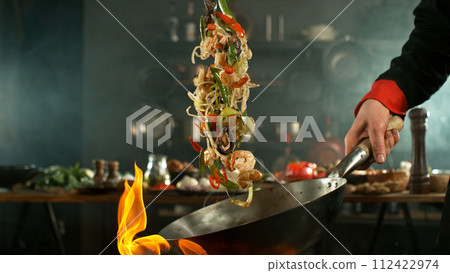 Freeze motion of flying asian wok noodles with prans and vegetable. The concept of meat preparation. 112422974