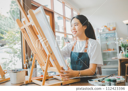 Art student drawing with watercolor painting on canvas doing some art projects on studio workshop Art student drawing with watercolor painting on canvas doing some art projects on studio workshop 112423396