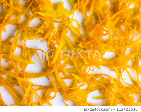 Fresh orange zest on a white plate. Raw citrus zest, grated orange peel, fresh zest on a white background. Fresh orange zest on a white plate. Raw citrus zest, grated orange peel, fresh zest on a white background. 112423636