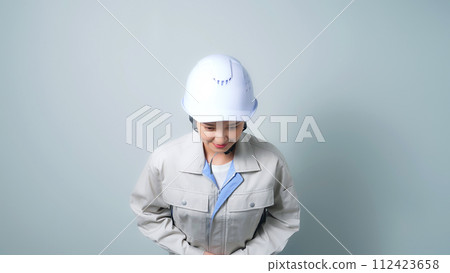 A woman in work clothes bowing 112423658