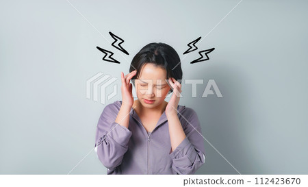 A woman wearing sportswear suffering from a headache 112423670