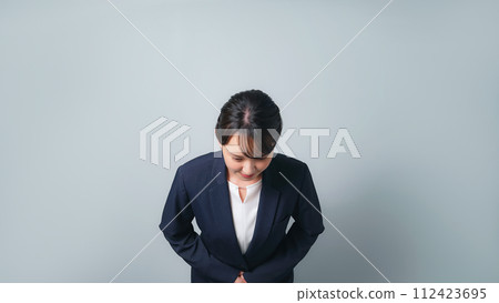 一個穿著西裝的女人鞠躬 一個穿著西裝的女人鞠躬 112423695