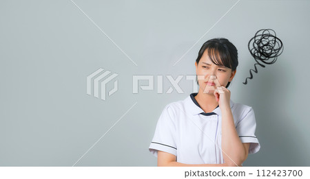一個穿著白大褂的沮喪的女人 一個穿著白大褂的沮喪的女人 112423700