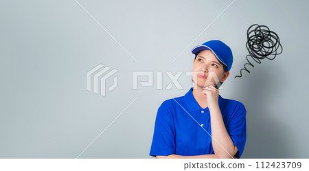 A woman wearing work clothes who is worried A woman wearing work clothes who is worried 112423709