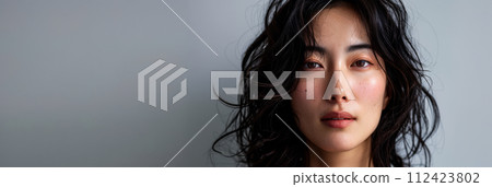Beauty portrait of a natural young Japanese woman with a soft grey copy space background 112423802