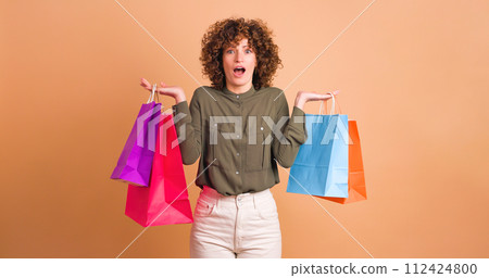 Happy woman with shopping paper bags in beige studio 112424800