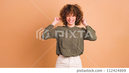 Stunned young woman standing with opened mouth on beige background 112424809