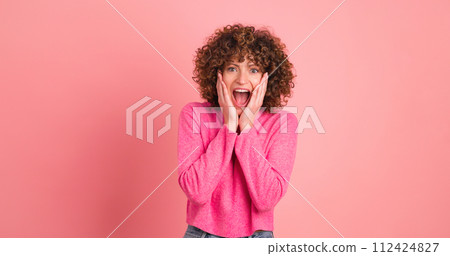 Stunned young woman standing with opened mouth on pink background 112424827
