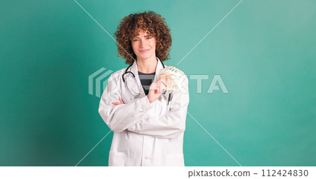 Happy young woman doctor showing money Happy young woman doctor showing money 112424830