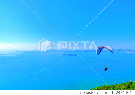 滑翔傘飛行員在晴朗的天空中飛越小子岳 112425104