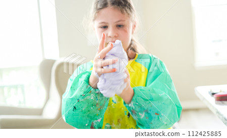 In a modern kitchen, a homeschooled girl is engrossed in creating homemade slime, a fun and educational hands-on project that enhances her creativity and problem-solving skills. In a modern kitchen, a homeschooled girl is engrossed in creating homemade slime, a fun and educational hands-on project that enhances her creativity and problem-solving skills. 112425885