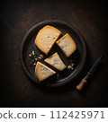 Top view of cheese on a black plate. AI generated. 112425971