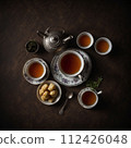 Top view of tea and sweets on a brown table. AI generated. 112426048