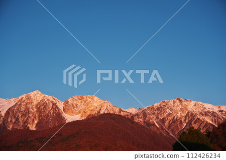 Dawn over the Ushiro Tateyama Mountain Range from the Hakuba Iwatake Mountain Resort campsite in autumn 112426234