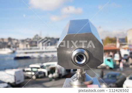Coin-operated binoculars looking out over city , 112426502