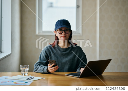 一個操作智能手機的年輕女子 112426808